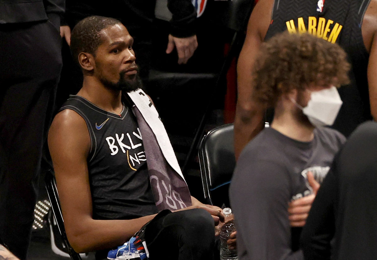 Kevin Durant sitting on the Nets' bench.