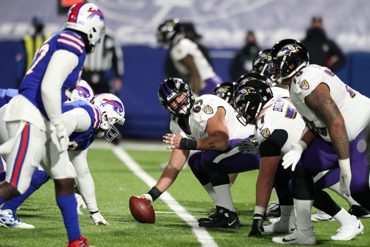 Baltimore Ravens and Buffalo Bills players lined up before a snap in a game.