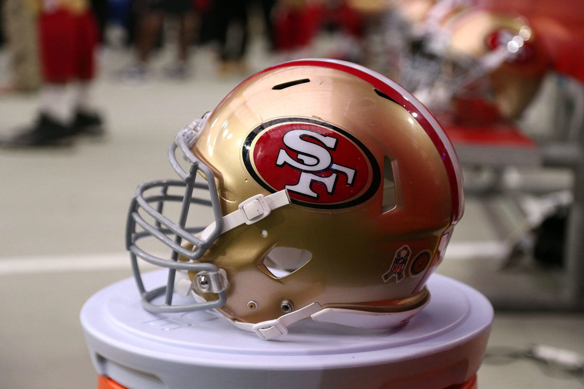 A San Francisco 49ers helmet sitting on a water cooler.
