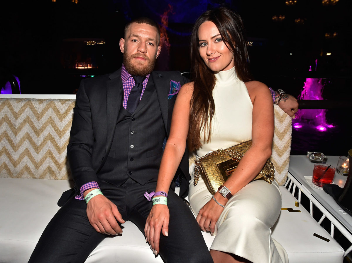 Conor McGregor sits with his wife.