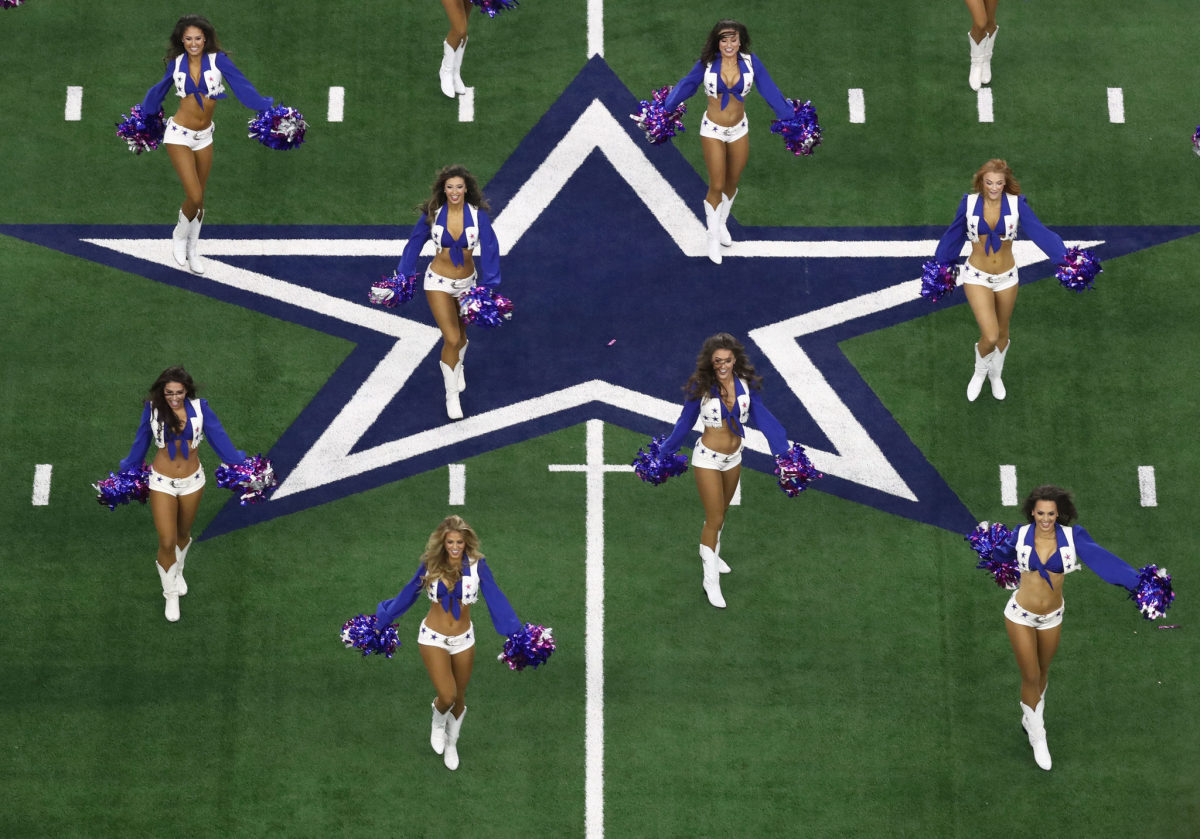 The Dallas Cowboys cheerleaders performing on the centerfield logo.
