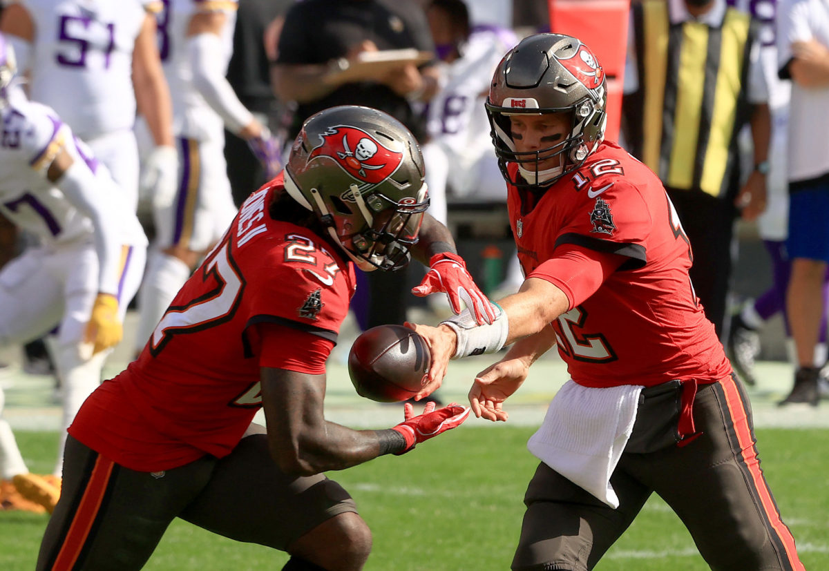 Tampa Bay Buccaneers quarterback Tom Brady hands off to Ronald Jones II during a game against the Vikings.