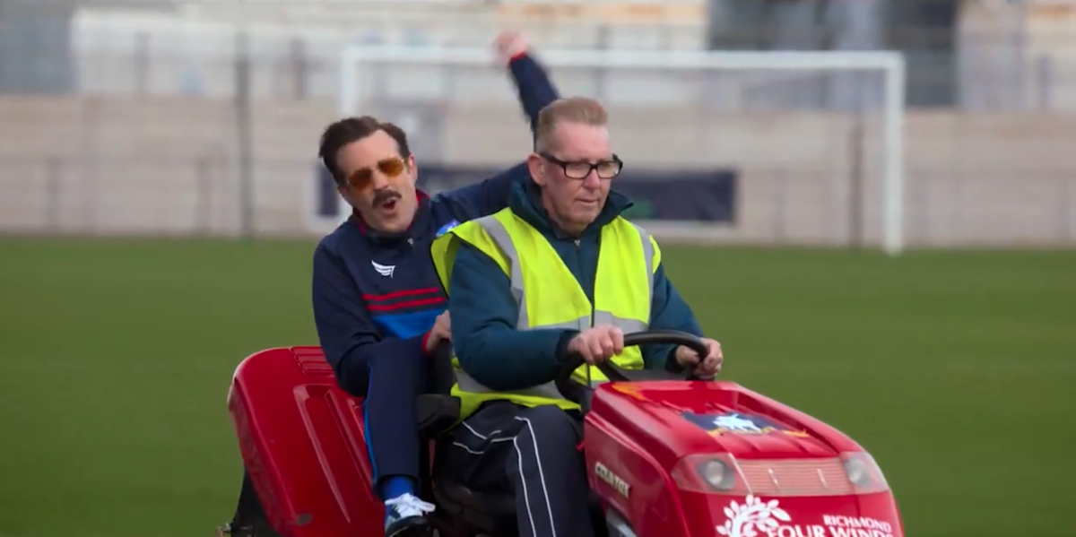 Jason Sudeikis as Ted Lasso, riding a mower on AFC Richmond's field in the season two trailer of the Apple TV show.