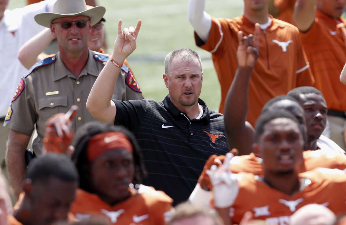 Tom Herman doing the "Hook 'Em Horns" while singing Texas' school song "The Eyes of Texas" after a game.