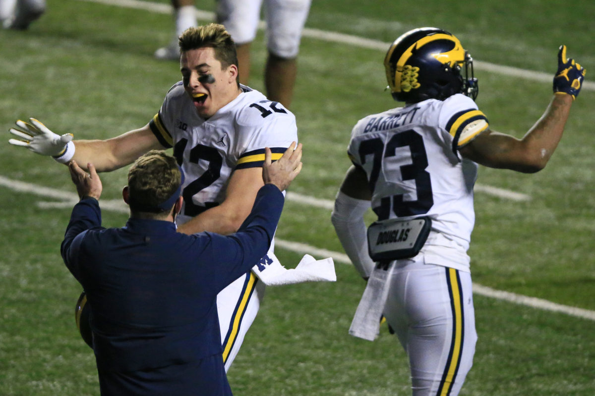 Michigan quarterback Cade McNamara celebrates on the field after a win.