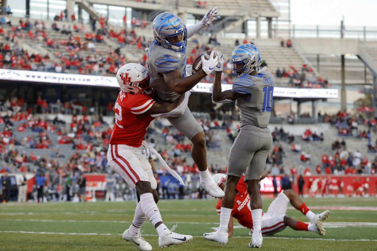 Memphis football's Antonio Gibson leaps for a touchdown against a Houston defender.