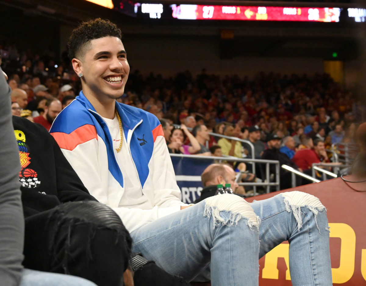 Charlotte Hornets guard LaMelo Ball on the sideline of a college game.