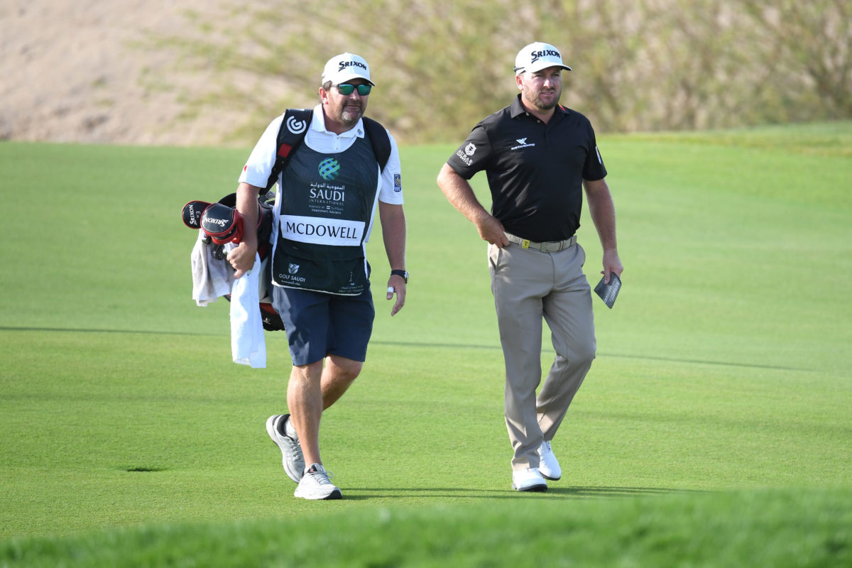 Graeme McDowell walks the course with his caddie.