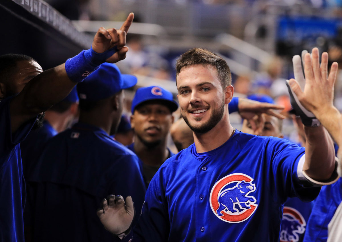 Kris Bryant high-fiving his teammates in the dugout.
