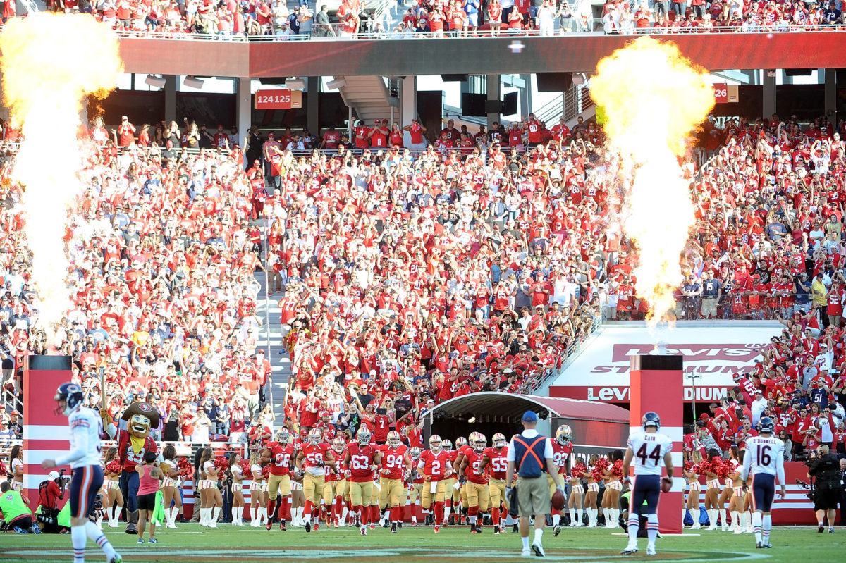 San Francisco 49ers players running onto the field.