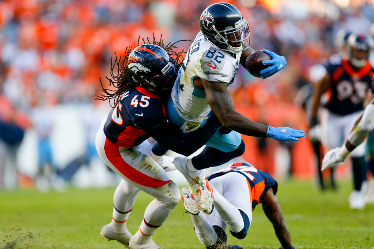 Tennessee Titans tight end Delanie Walker gets tackled by a Broncos defender.