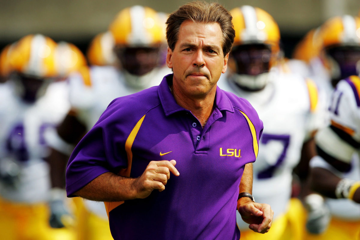 Nick Saban jogs onto the field before an LSU game.