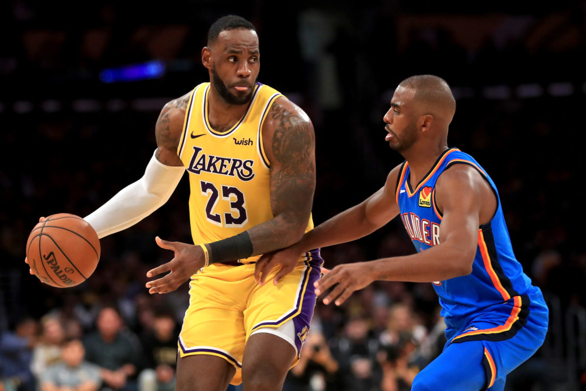 LeBron James of the Los Angeles Lakers backs down Oklahoma City Thunder guard Chris Paul during an NBA game.