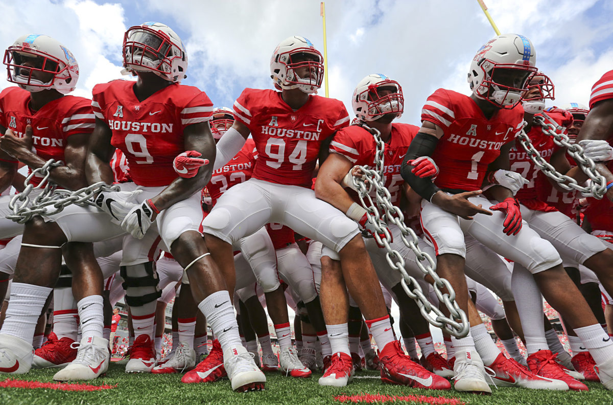 Houston Football players getting ready for a game by holding chains.