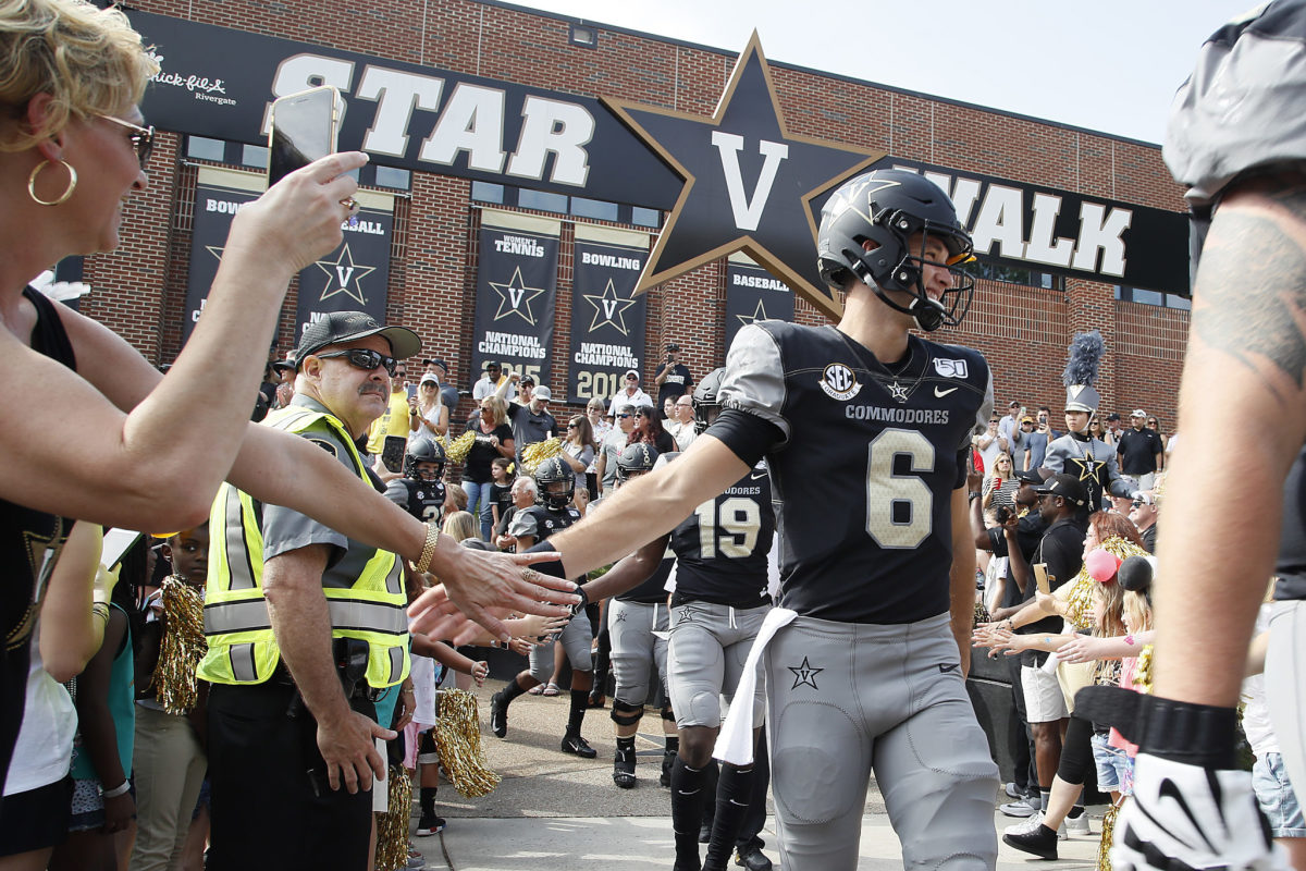 A Vanderbilt player shakes hands with a fan.