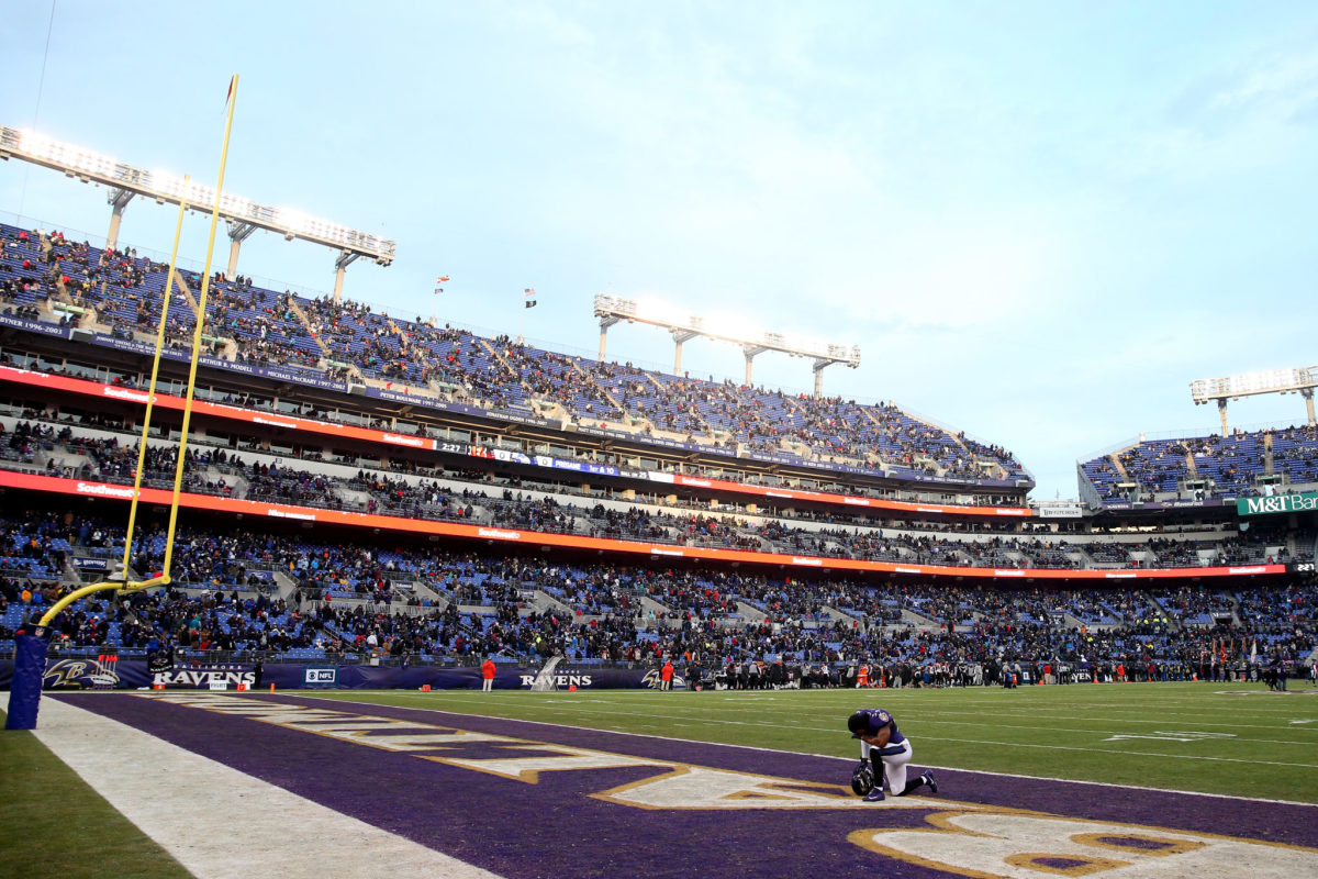 A Baltimore Ravens player kneeling in the end zone.
