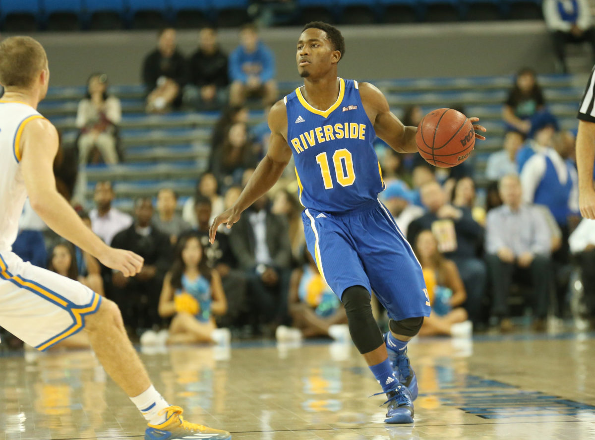 A UC Riverside basketball player with the ball against UCLA.