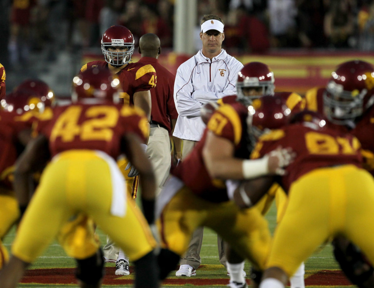 Lane Kiffin watching the USC offense warmup before a game.