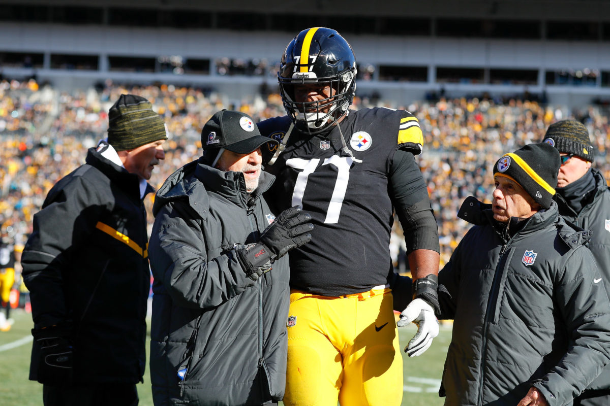 Marcus Gilbert #77 of the Pittsburgh Steelers is helped off the field by trainers