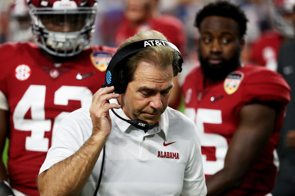 A closeup of Alabama football coach Nick Saban speaking into his headset.
