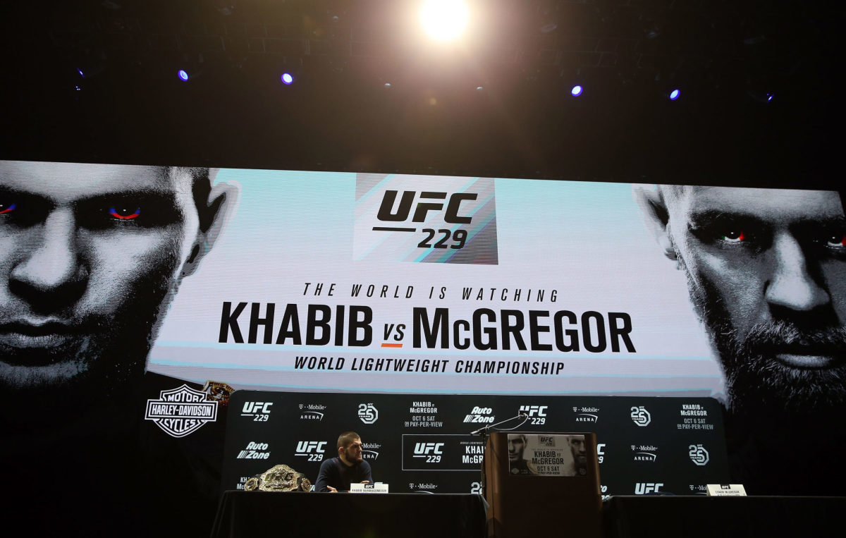 Khabib sitting at a podium speaking during a promo for his fight against Conor McGregor.