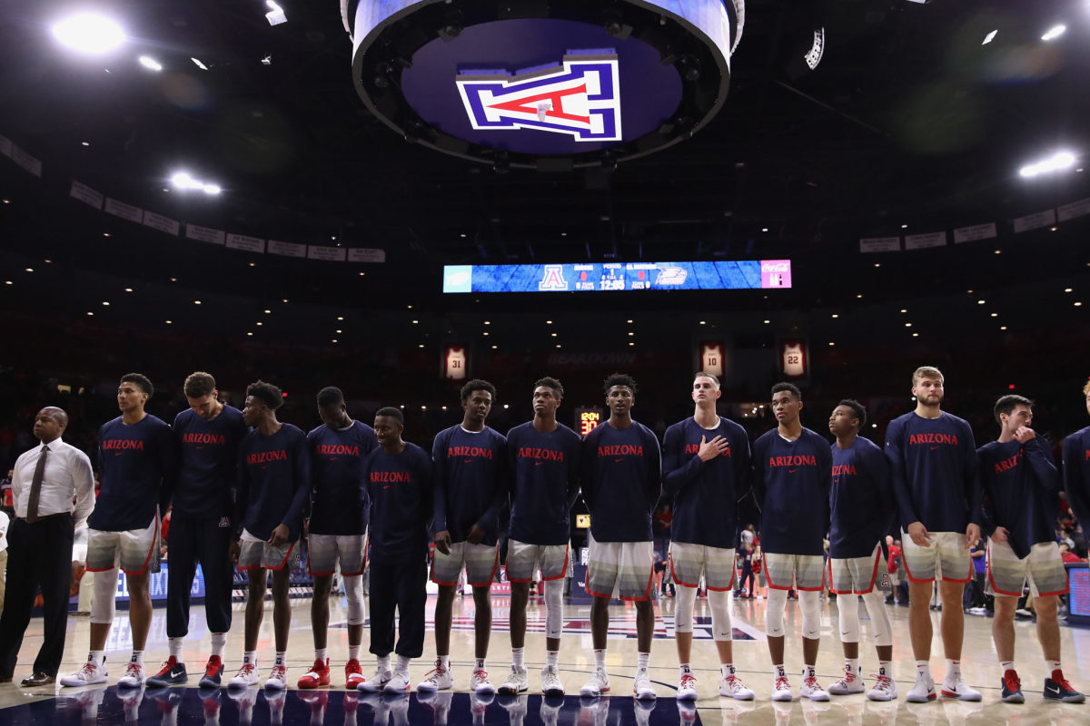 The Arizona Wildcats basketball team standing during the National Anthem.