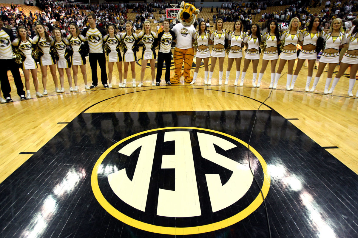 Missouri's cheerleaders with the team's mascot on a basketball court.