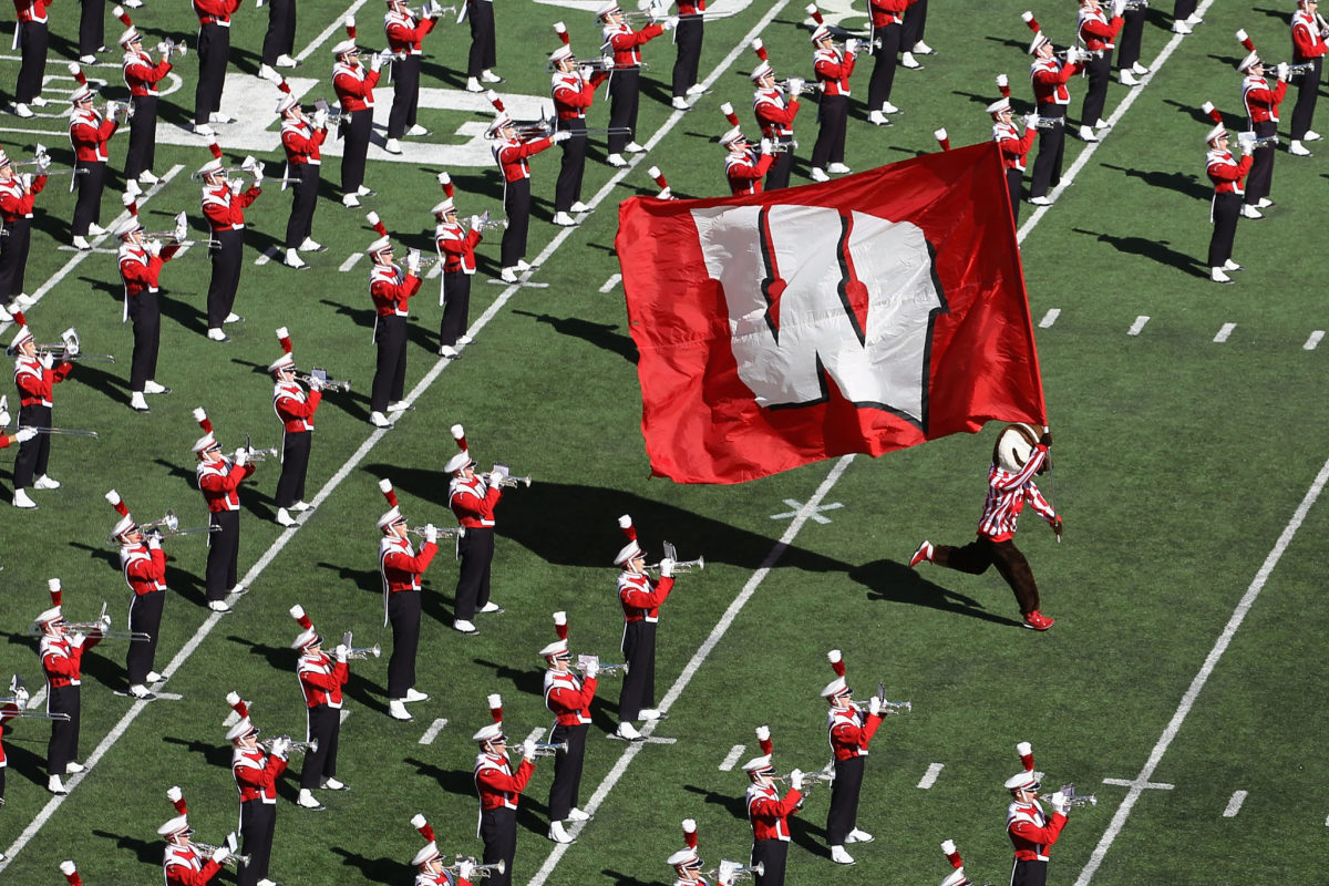 Bucky the Badger waves the Wisconsin flag with the band.