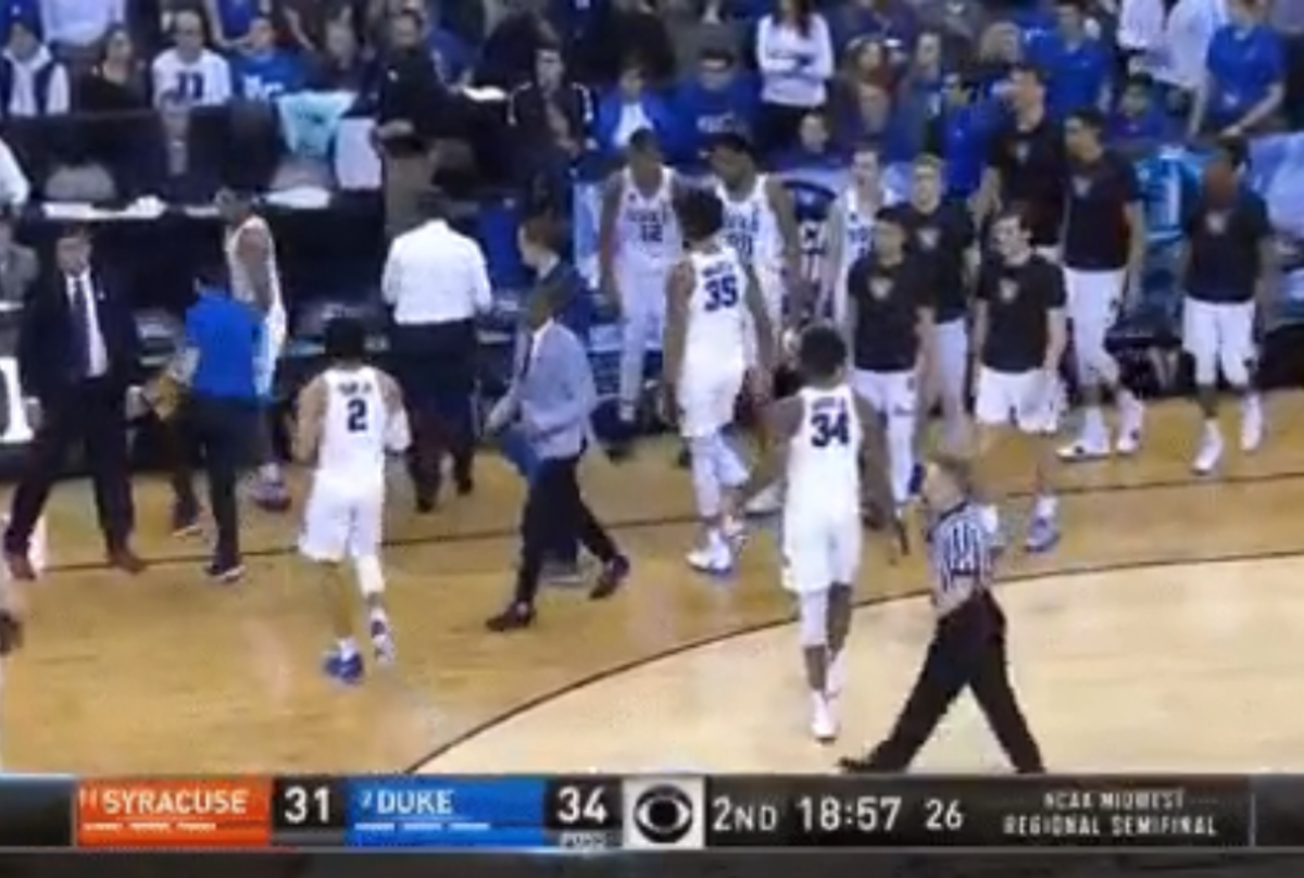 An angry Coach K tosses his jacket.