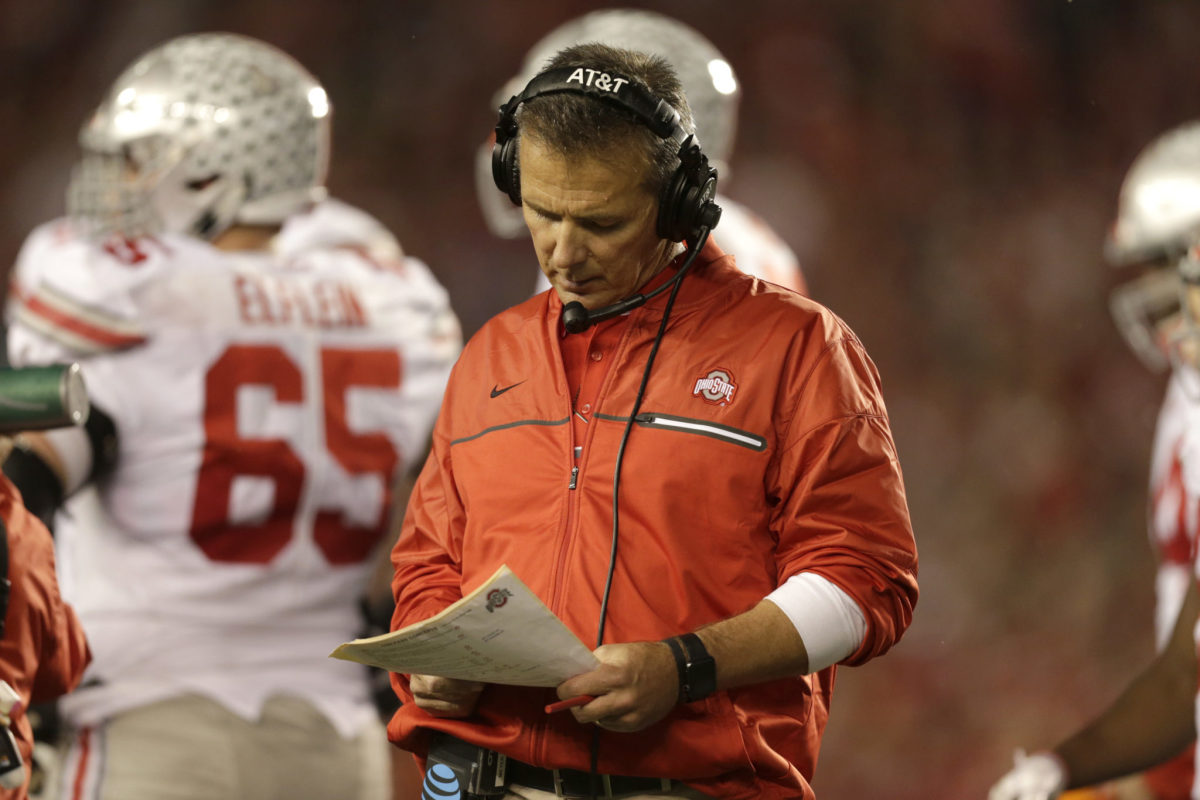 Urban Meyer looking at his playbook during an Ohio State game.