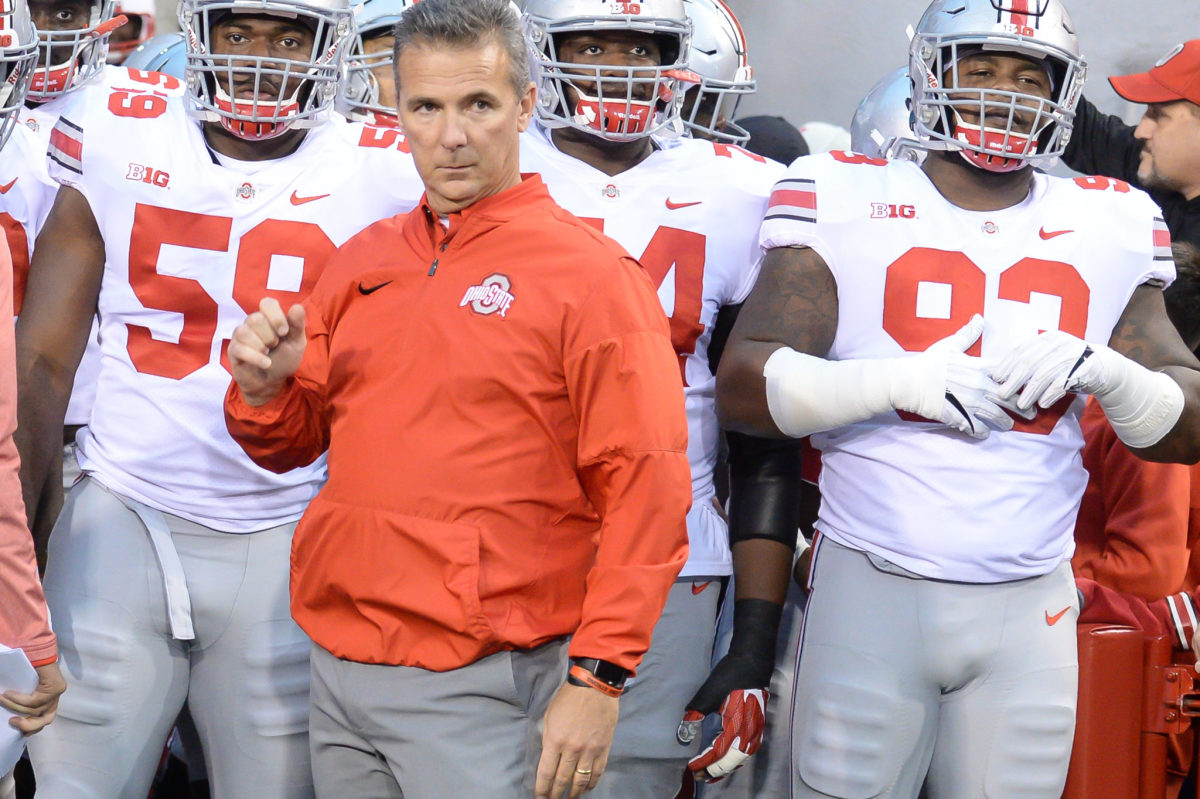 Urban Meyer standing with his Ohio State football team.