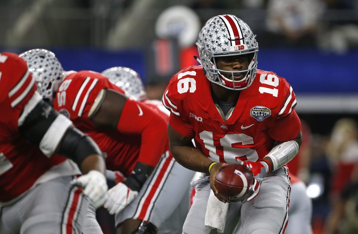 J.T. Barrett handing the ball off during an Ohio State football game.