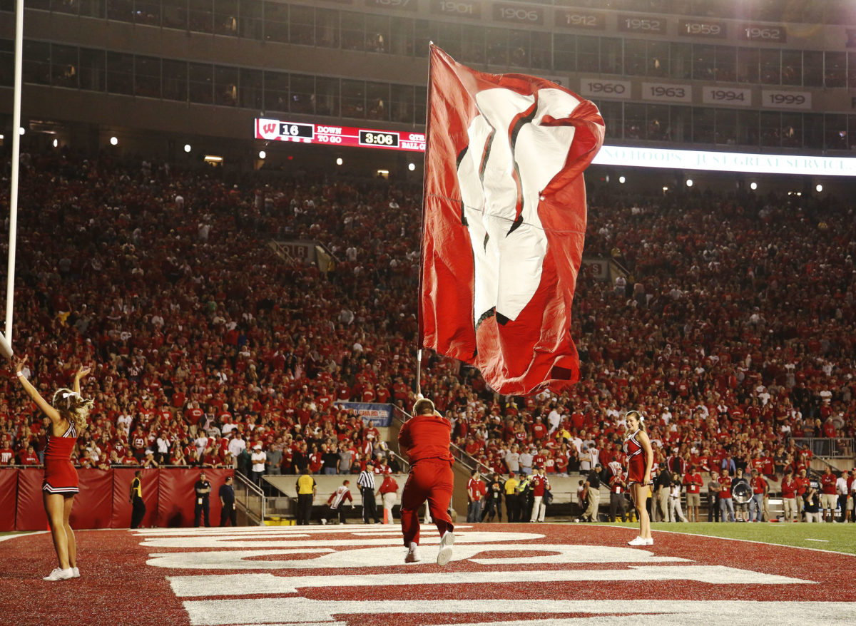 A Wisconsin cheerleader waves the flag after a score.