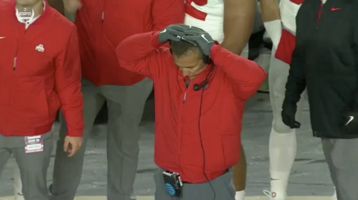 Urban Meyer with his hands on his head.