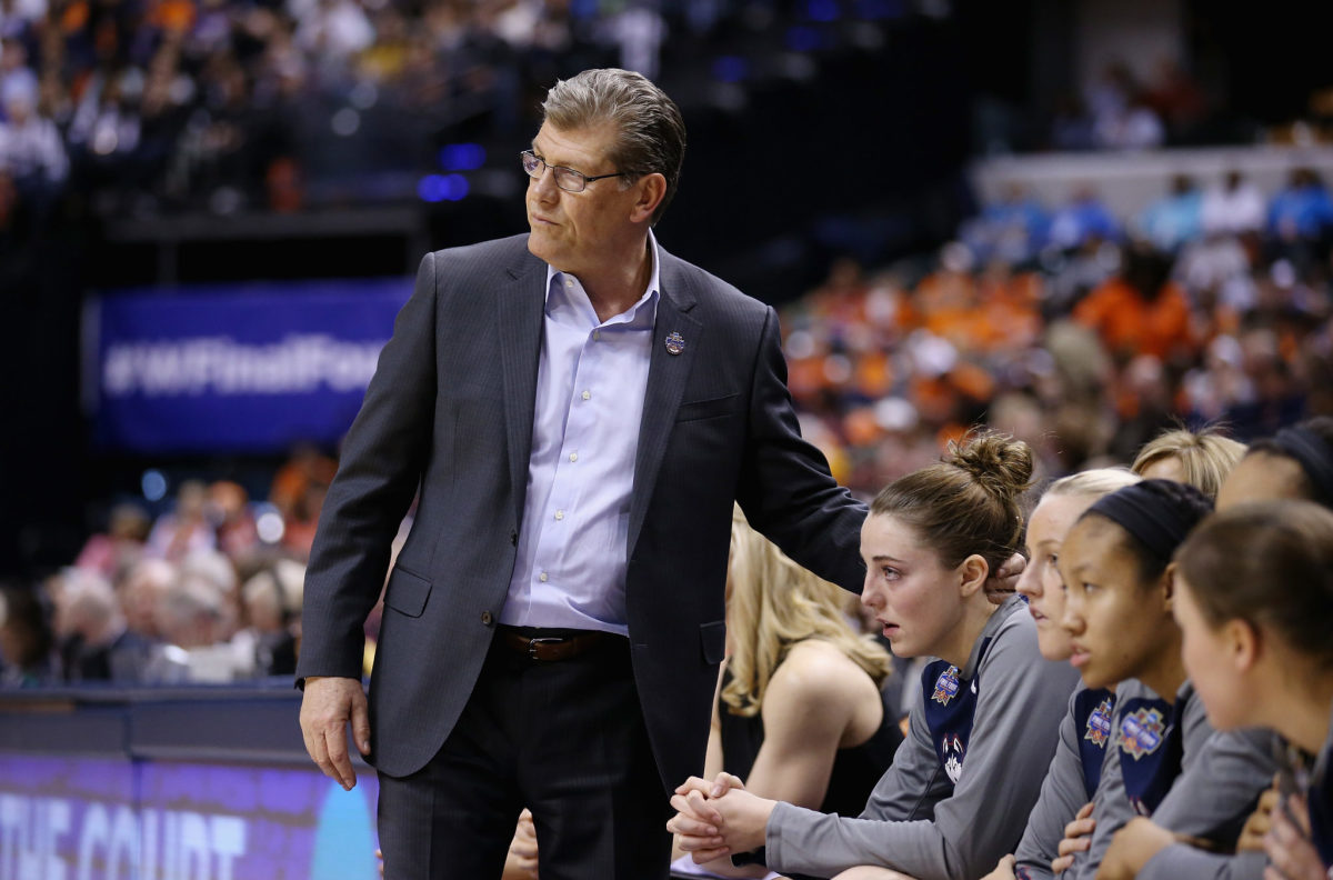 Geno Auriemma patting one of his players on the back.
