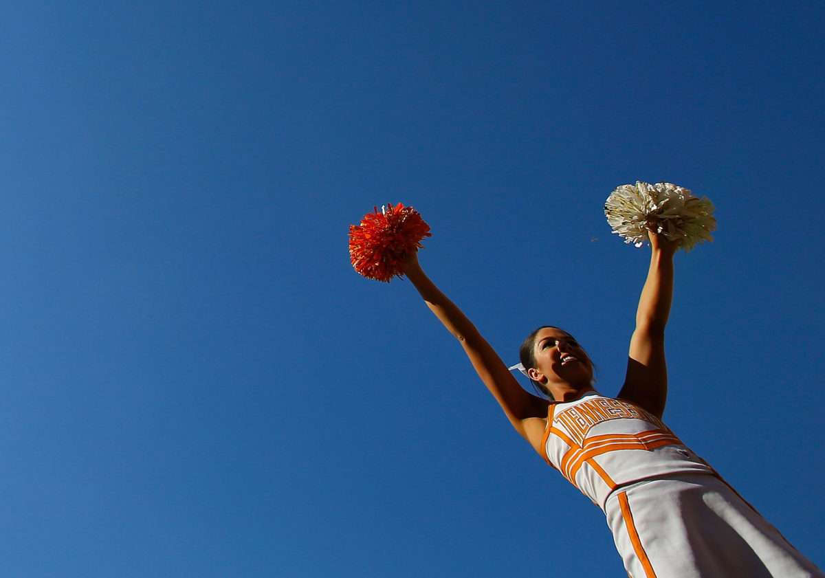 A Tennessee cheerleader with her hands in the air.