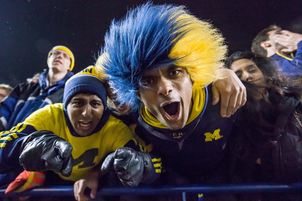 Some festive Michigan fans cheer during a college football game between the Michigan Wolverines and the Minnesota Golden Gophers at Michigan Stadium.