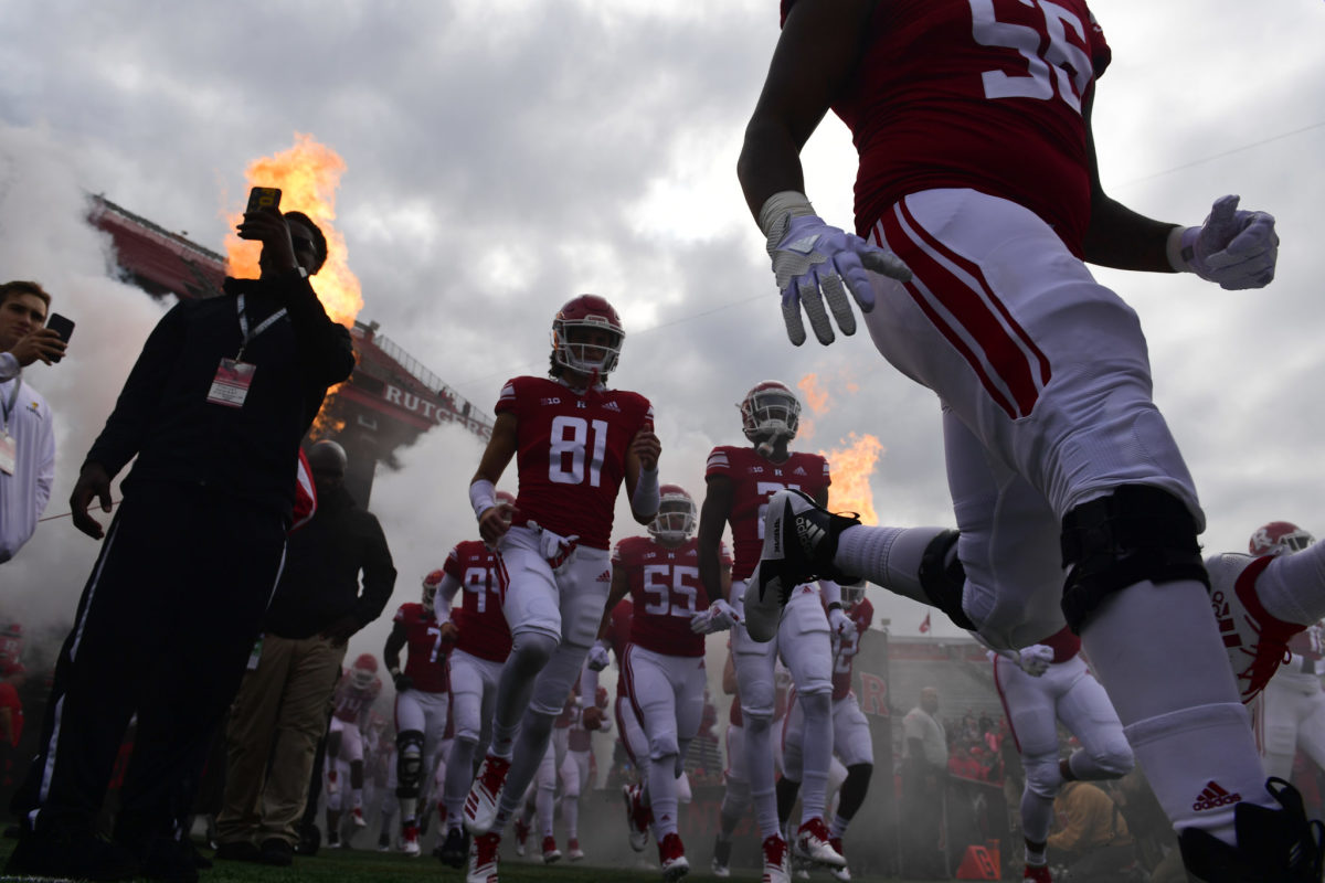 Rutgers players run onto the field before a game.