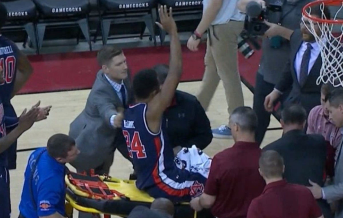 Anfernee McLemore waving to the crowd on a stretcher.