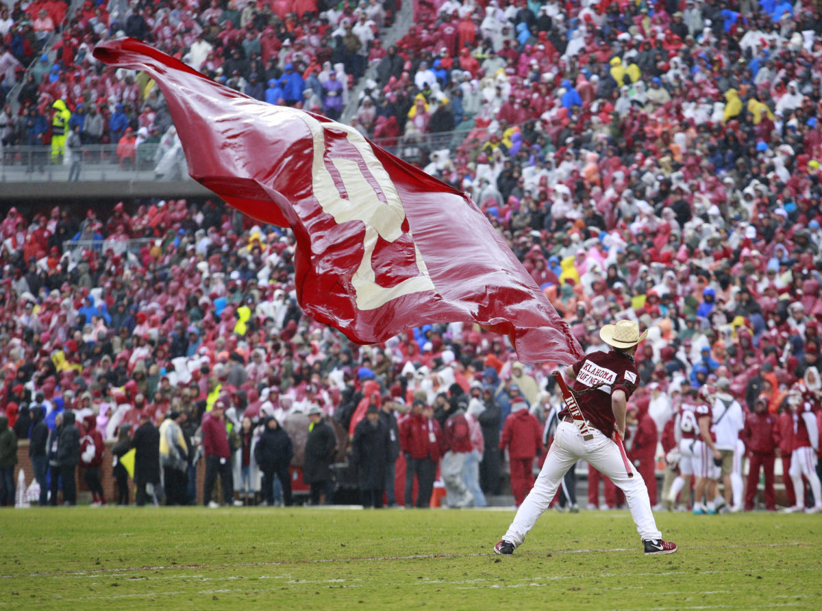 A member of Oklahoma's spirit squad waving a flag at a game.