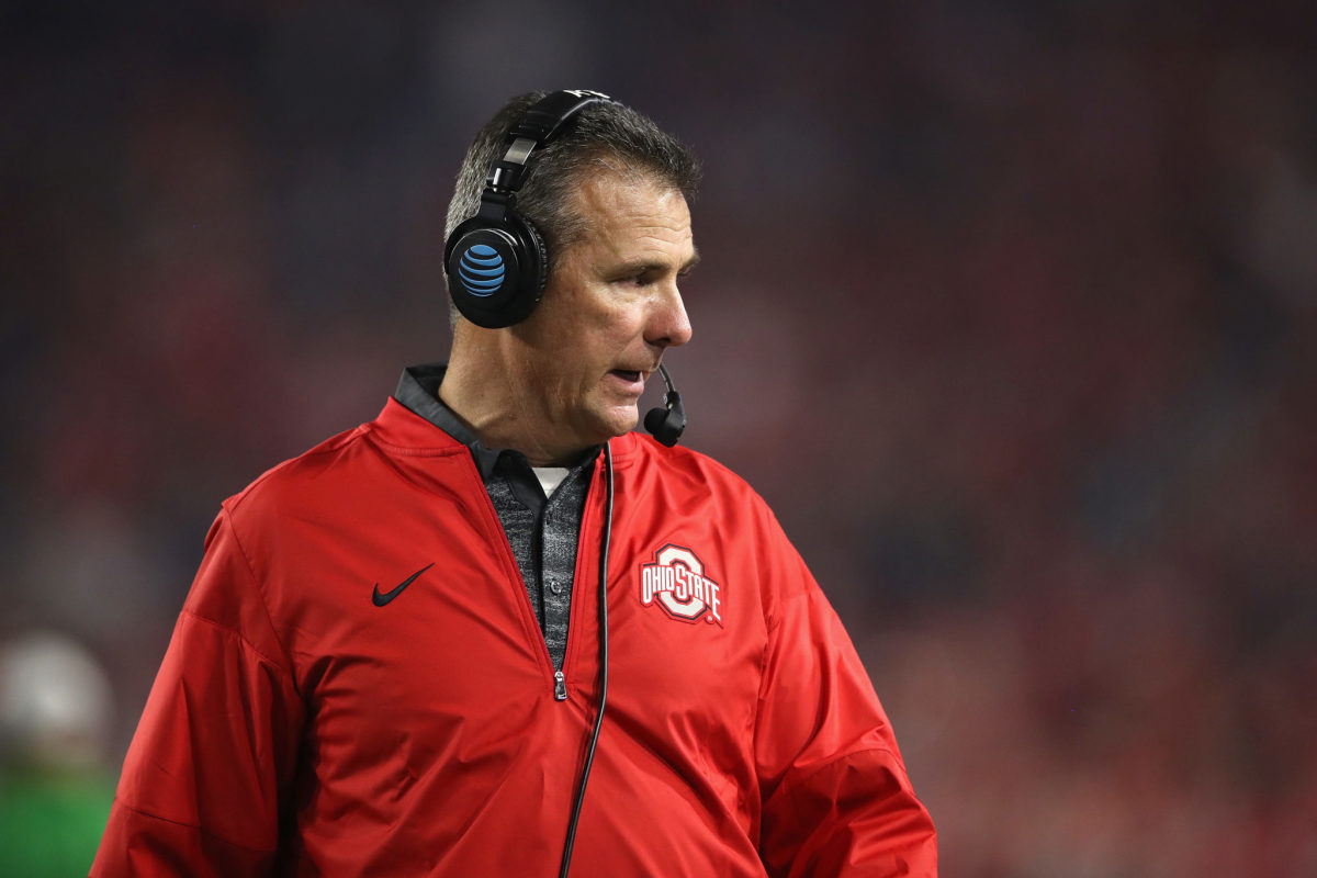 A closeup of Urban Meyer wearing a red Ohio State jacket.