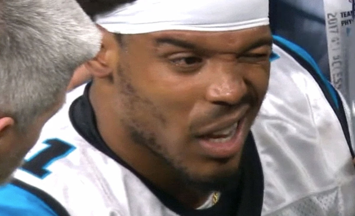 Cam Newton squinting at a trainer.