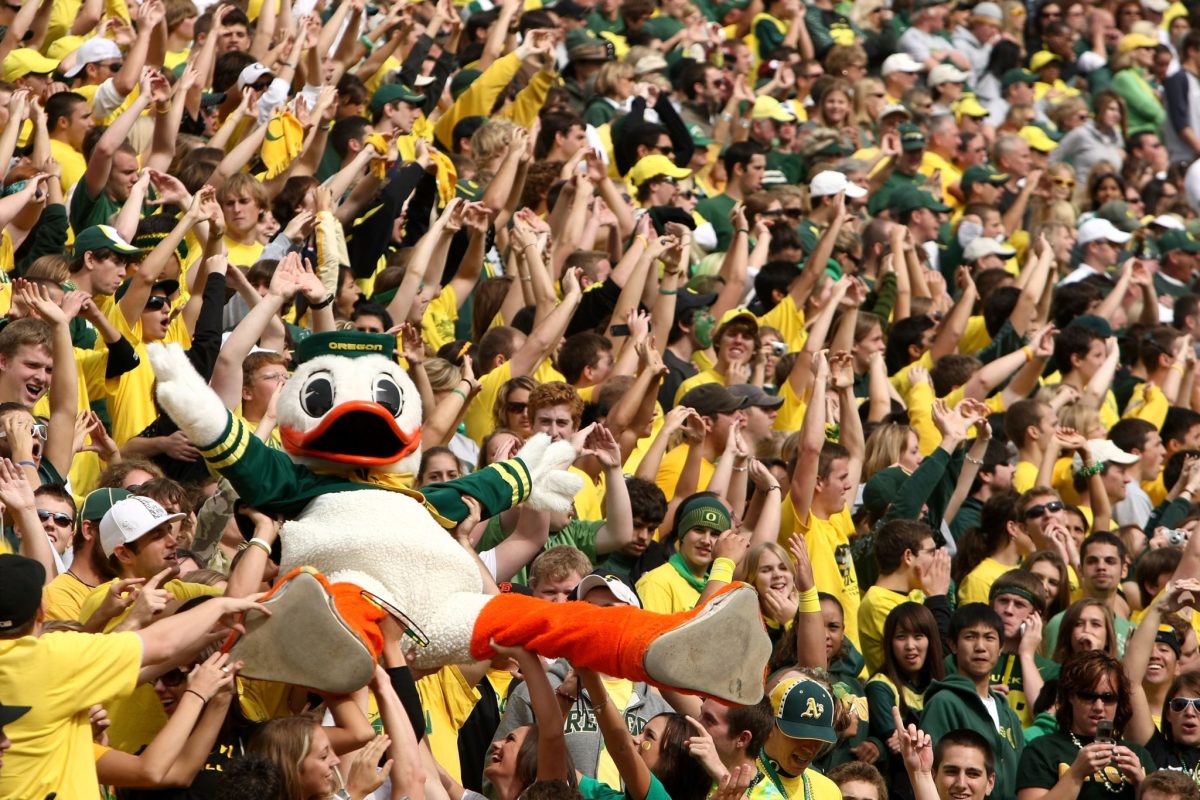 Oregon fans carrying the mascot through the crowd.