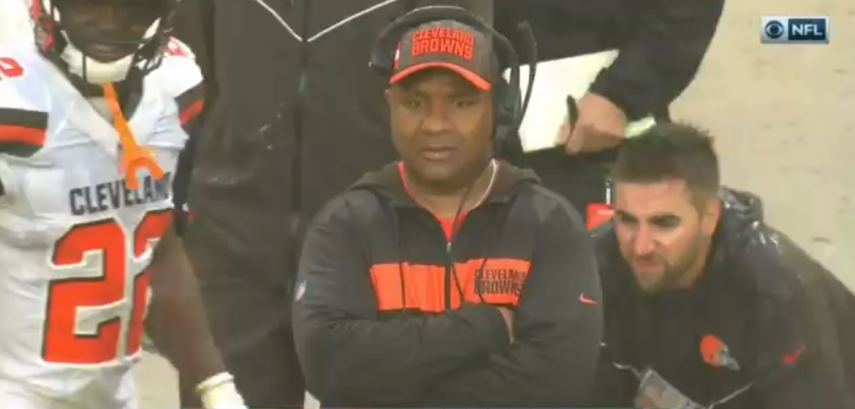 Hue Jackson stands on the sidelines in the rain.