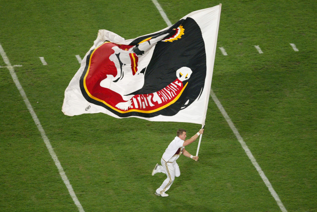 A Florida State Cheerleader running with a flag.