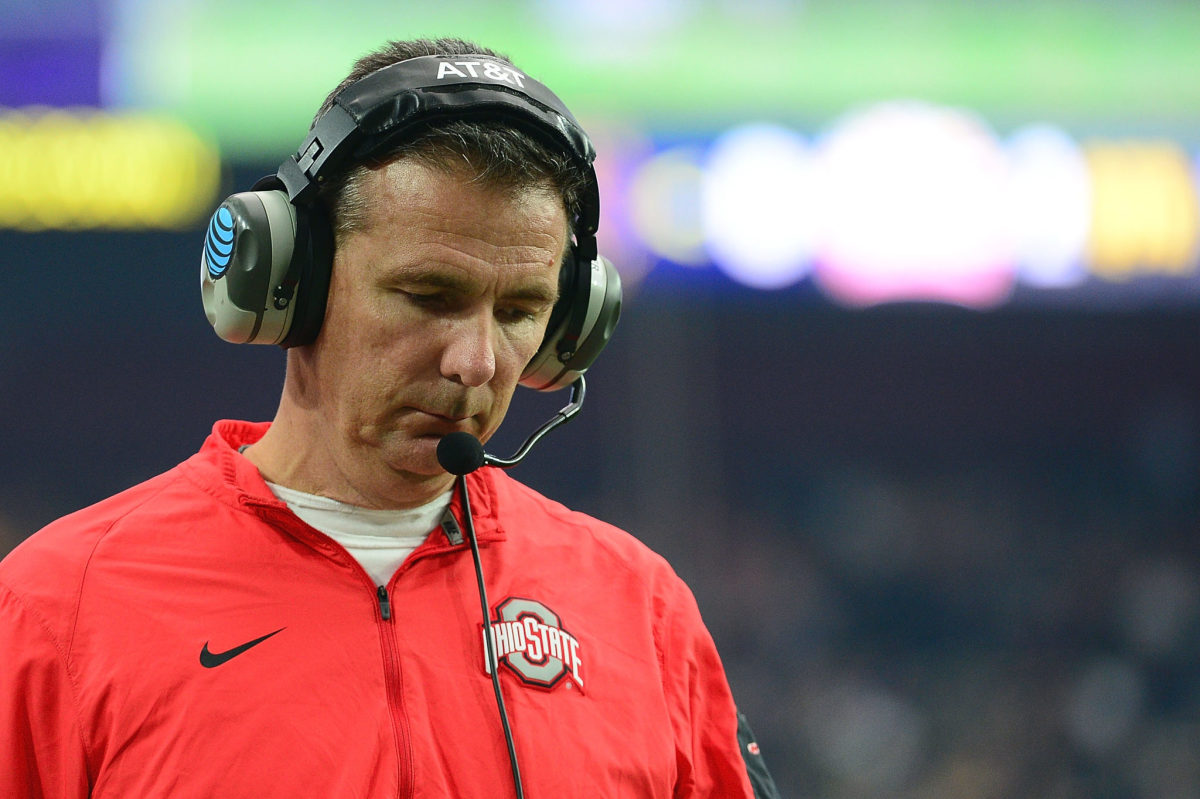 A closeup of Urban Meyer wearing a headset during an Ohio State football game.