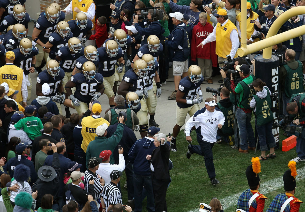 Notre Dame football players running onto the field.