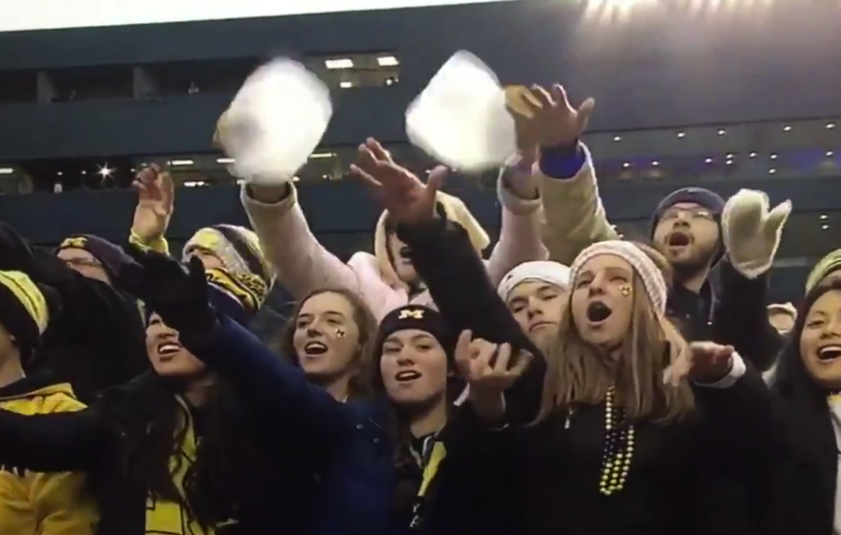 A male Michigan fan makes a questionable gesture to the camera.