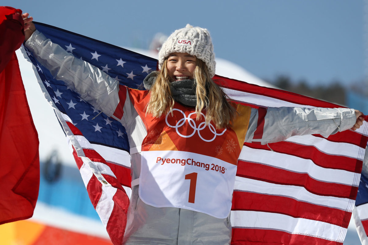 Chloe Kim holding the American flag.
