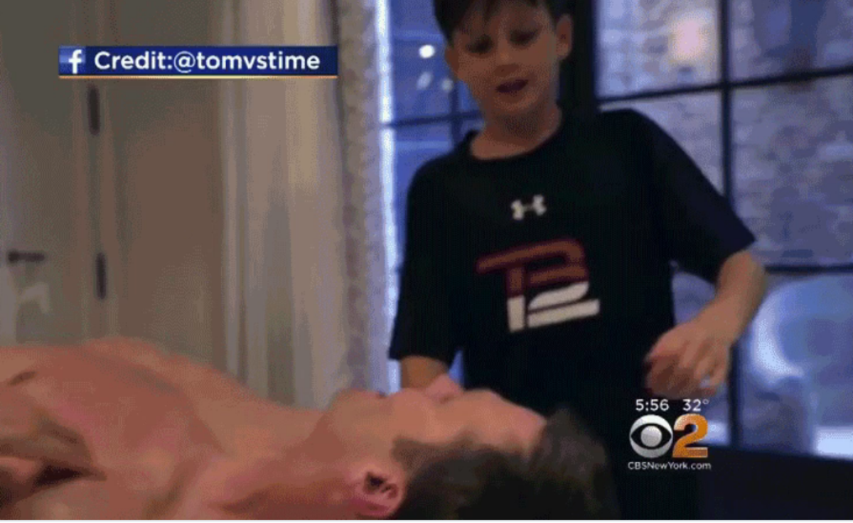 Shirtless Tom Brady talks to his son.